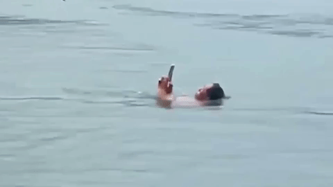 Du khách thản nhiên bơi lội trong hồ nước sâu dù mắt vẫn dán vào điện thoại