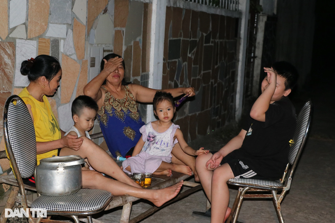 Người dân huyện Hưng Nguyên ra đường hóng mát chờ có điện trở lại, có khi phải chờ đến nửa đêm